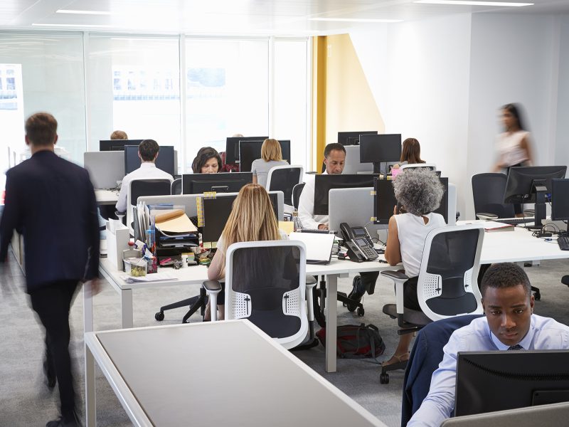 Man walking through a busy open plan office